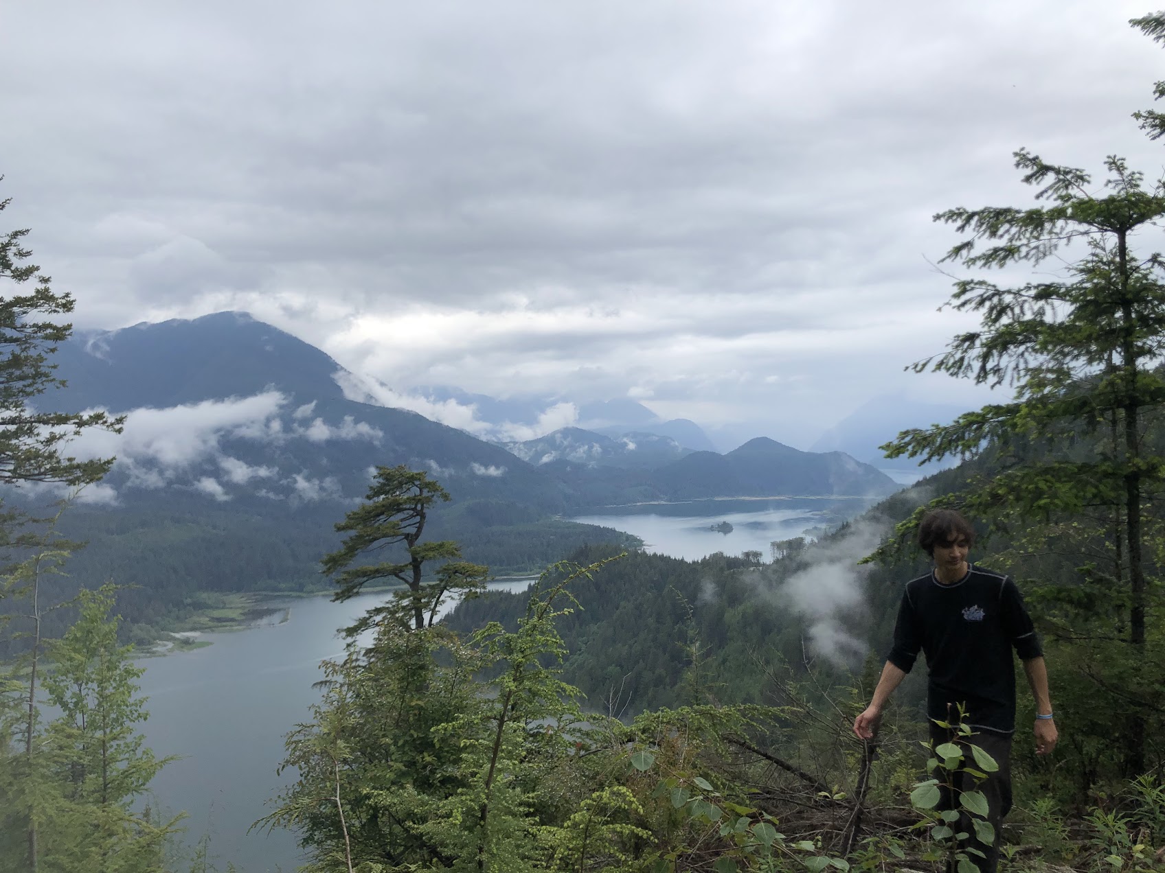 Nick walking above a misty mountain lake in British Columbia